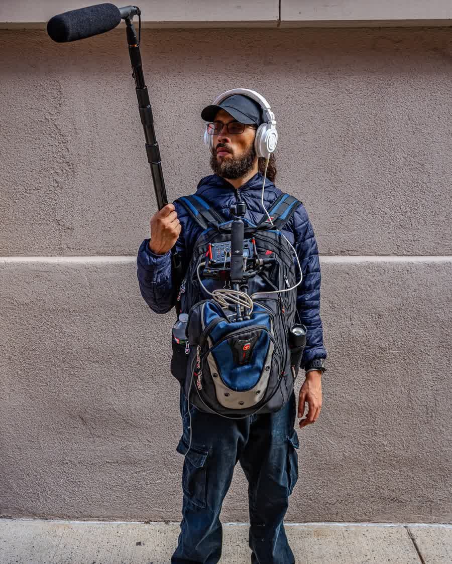 David Rodriguez recording location sound with a boom microphone and a bag rig