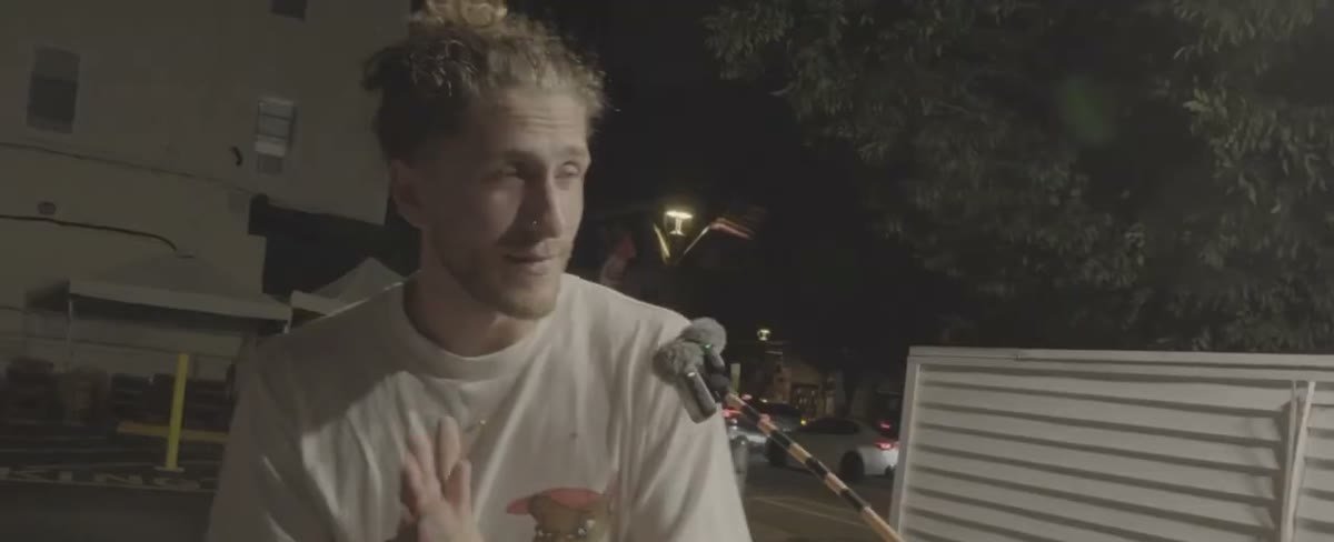 A fan speaking into a microphone at night outside the stadium
